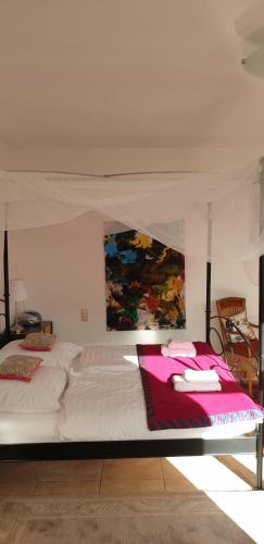 リューベックにあるFerienwohnung-Ulindeの白いベッド1台付きのベッドルーム1室(壁に絵画付)