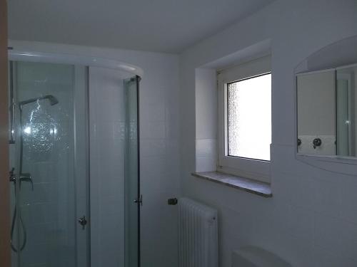 uma casa de banho com uma cabina de duche em vidro e uma janela em Ferienhaus zur Waldfee (Holla die Waldfee) em Cuxhaven
