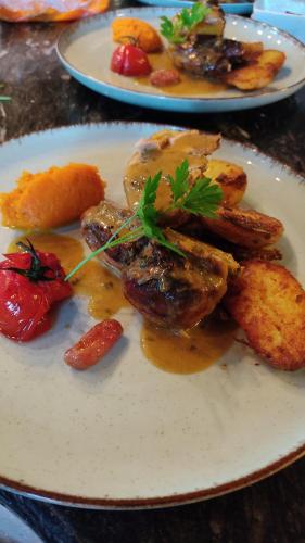 a plate of food with meat and potatoes on a table at Atelier des sens 89 in Évry