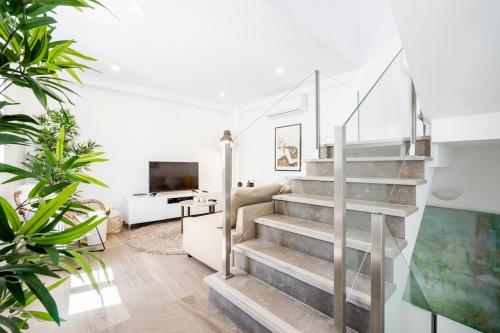 a staircase in a living room with a couch and a tv at Pessoa/Rico - Historical Tavira House in Tavira