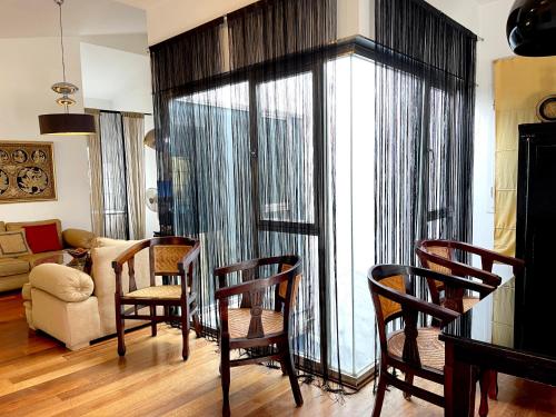 a living room with a dining table and chairs at Ático en Plaza de la Constitución 3 bedrooms in Málaga