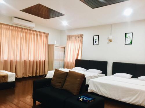 um quarto de hotel com duas camas e um sofá em Inapan Taman Herba em Kepala Batas
