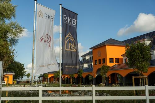 zwei Flaggen vor einem Gebäude in der Unterkunft Luxus Resort Rügen Residenz Kubitzer Bodden in Rambin