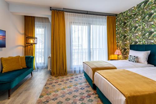 een hotelkamer met 2 bedden en een bank bij Green Parrot Hotel Istanbul in Istanbul