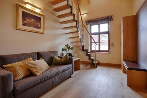 a living room with a couch and a staircase at homie hotel wiener botschaft in Veitshöchheim