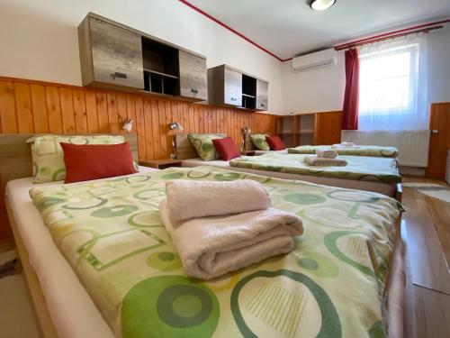 two beds with towels on them in a room at Hargita Panzio in Vecsés