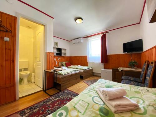 a bedroom with a bed and a bathroom with a sink at Hargita Panzio in Vecsés