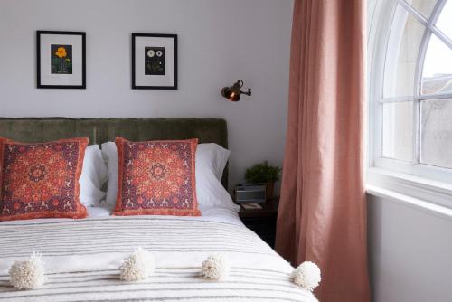 a bedroom with a bed with orange pillows and a window at Artist Residence Bristol in Bristol