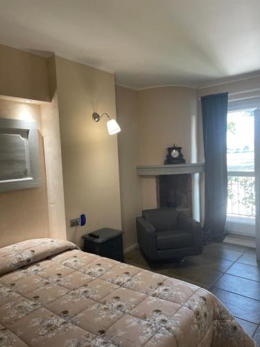 a bedroom with a bed and a chair and a fireplace at ANTICA VILLA CUNEO- Guest House - "B&B e non un Hotel a Cuneo" in Cuneo