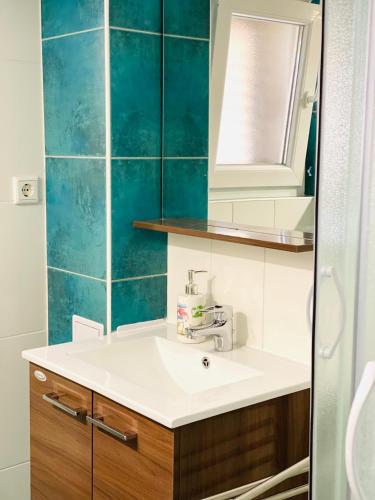 ein Badezimmer mit Waschbecken und einer blau gefliesten Wand in der Unterkunft Villa DA in Zablaće