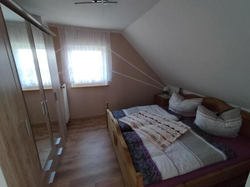 a attic bedroom with a bed and a window at FeWo Zur Alten Drechslerei in Freital