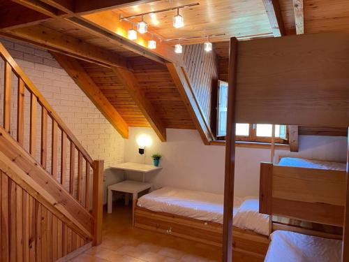 ビエラにあるDuplex Con Encanto En Vielhaの二段ベッド2組と階段が備わる客室です。