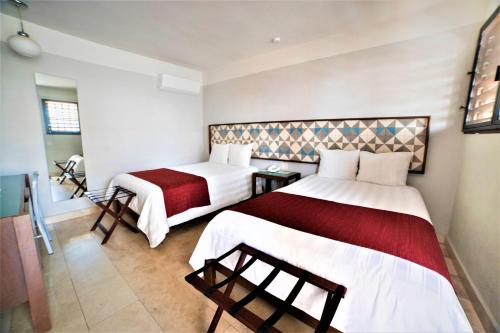 a hotel room with two beds in a room at Hotel Caribe Merida Yucatan in Mérida