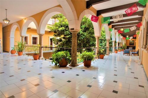 a hallway with potted plants in a building at Hotel Caribe Merida Yucatan in Mérida