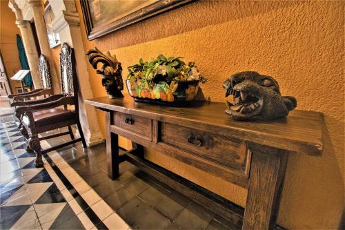 a table with a vase of flowers on top of it at Hotel Caribe Merida Yucatan in Mérida