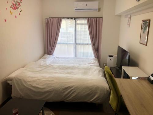 - une petite chambre avec un lit et une fenêtre dans l'établissement 駅南うちやまビル1, à Fukuoka