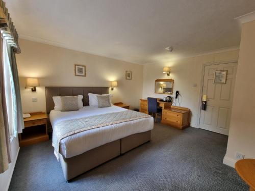 A bed or beds in a room at Hadlow Manor 
