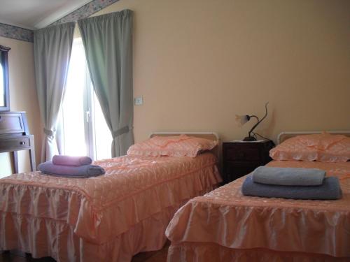 1 dormitorio con 2 camas y ventana en Casa Vacanze da Sina, en Linguaglossa