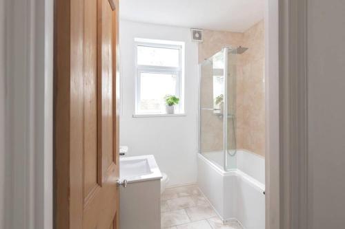 uma casa de banho com um lavatório, um WC e uma janela. em Relax in Stunning Apartment In Leafy Victorian Area em Cardiff