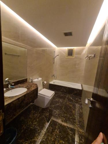 ein Badezimmer mit einem Waschbecken, einem WC und einer Badewanne in der Unterkunft روز نيري 2 in Khobar