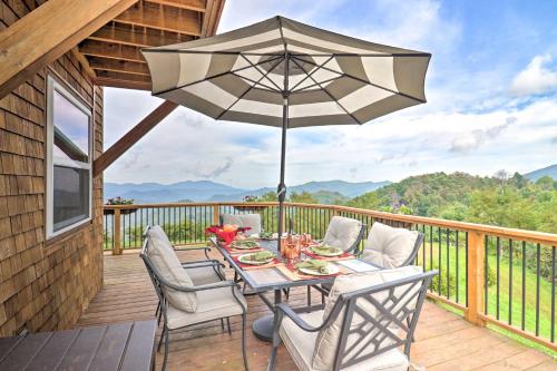 una mesa y sillas en una terraza con sombrilla en Stunning Mountain Views Hot Springs Hideaway!, en Sandymush