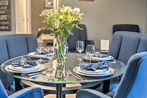 a table with plates and glasses and a vase of flowers at 32 Mi to DC Lower-Level Woodbridge Apt with Patio! in Woodbridge