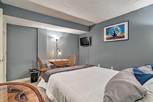 a bedroom with a bed and a table and a tv at 32 Mi to DC Lower-Level Woodbridge Apt with Patio! in Woodbridge