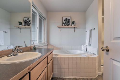 a white bathroom with a tub and a sink at Charming Redmond Townhome with Resort Amenities in Redmond
