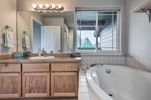 a bathroom with a tub and a sink and a mirror at Charming Redmond Townhome with Resort Amenities in Redmond