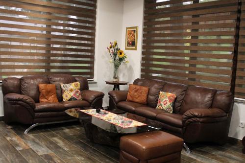 a living room with two leather couches and a table at Vila Jasen - Bjelašnica in Sarajevo