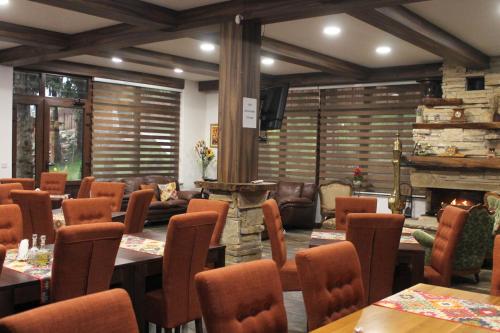 a restaurant with tables and chairs and a fireplace at Vila Jasen - Bjelašnica in Sarajevo