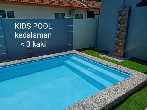 a swimming pool in front of a house at SITI HOMESTAY D' TELOK KEMANG PORT DICKSON (MUSLIM HOMESTAY) in Port Dickson