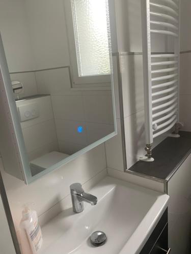 a white bathroom with a sink and a mirror at Messe-Apartment in Essen