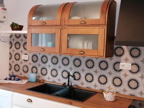 a kitchen sink with a wooden cabinet above it at Casa del Mare Appartamento Bucceri Salvatore in Letojanni