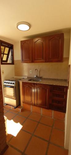 a kitchen with wooden cabinets and a sink and a stove at Pino Dorado in Punta del Este