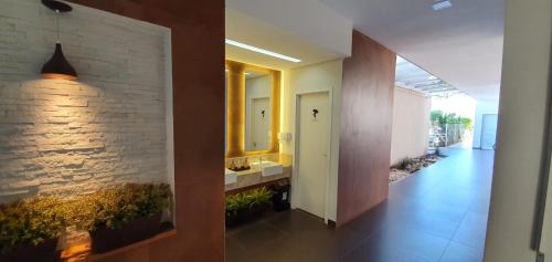a bathroom with two sinks and a brick wall at Hotel Fatti in Maringá