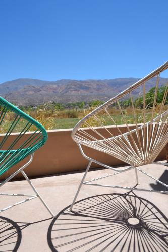 una silla en el balcón con vistas a las montañas en Cabañas Sixilera en Huacalera