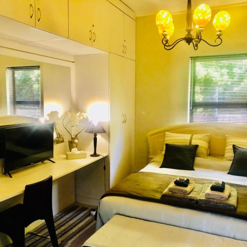 a bedroom with a bed and a desk and a television at Wellington Country House in Wellington