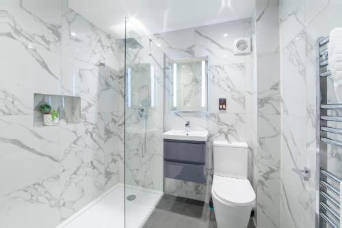 a white bathroom with a toilet and a shower at Minster's Reach York close to York Minster in York