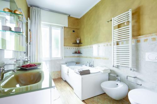 uma casa de banho com uma banheira, um lavatório e um WC. em Beatrice Apartment em Massa