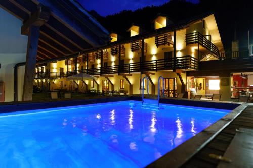 ein Schwimmbad vor einem Gebäude in der Nacht in der Unterkunft Chalet du Lys Hotel & SPA in Gressoney-la-Trinité