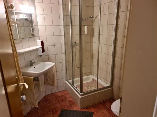 a bathroom with a shower and a sink at Auberge de Ballens in Ballens
