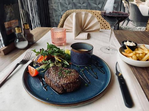 a steak on a blue plate on a table with fries at Hotel Du Commerce in Oostburg