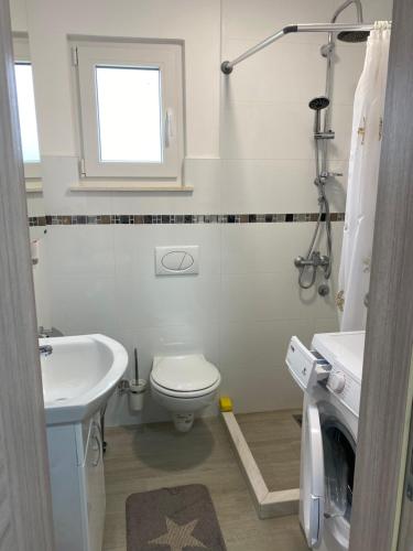 a white bathroom with a toilet and a sink at Bela Bar in Pečurice