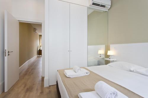 a bedroom with a white bed with two towels on it at RVA - Clerigos Apartments in Porto
