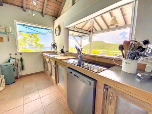 a kitchen with a sink and a large window at Aquamarine, private room in Villa Casa Blue pool sea view in Koolbaai
