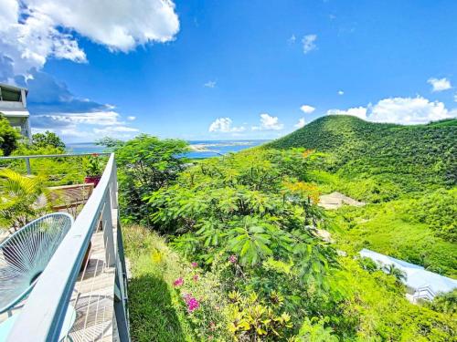 an ocean view from the balcony of a house at Aquamarine, private room in Villa Casa Blue pool sea view in Koolbaai