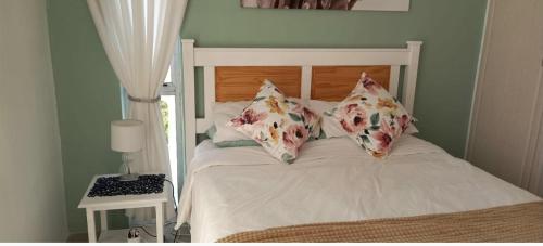 a bed with pillows on it in a bedroom at Sunrise Pool At 201 in Ballito