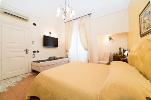 a bedroom with a bed and a couch and a tv at Hotel Villa Annalara charme and Relax in Amalfi