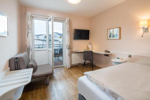 a hotel room with a bed and a desk at Schäfers Hotel, Self-Check-in, Cafe und Bäcker am Hotel in Vechta